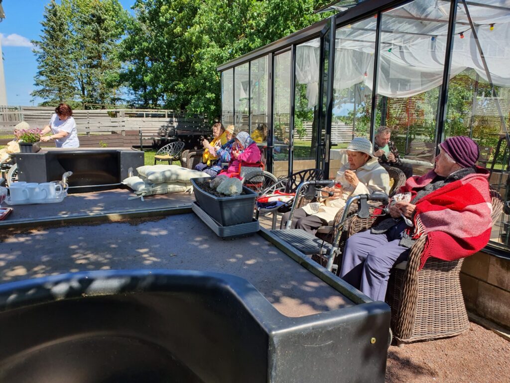 Viiratsi Hoolekandekeskuse elanikud veedavad aega õues ja istuvad koos hoovi puhkealal